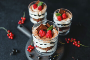 Sweet small homemade trifle dessert with raspberries, black currants, and cream cheese.