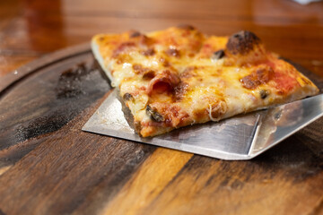 Close up pizza on woodden plate.