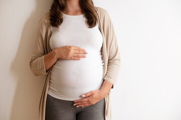 Portrait shot of young beautiful woman on third trimester of pregnancy. Close up of pregnant female...