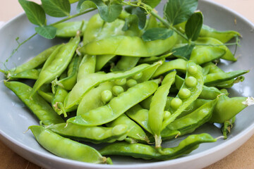 Young, green peas on a twig and on a Board close-up