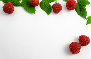 Ripe raspberries isolated on white background close-up. Beautiful red fresh raspberries with leaves along the contour on the table. Top view. Banner for the site. Free space for text