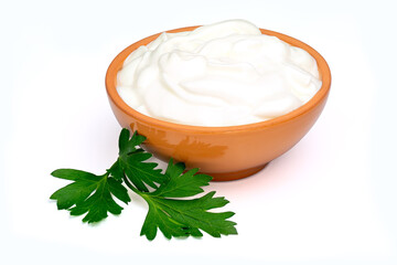 Sour cream, yogurt or soft cottage cheese in a ceramic bowl and parsley leaf isolated on white background. Natural dairy products. Full depth of field with clipping path.