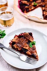 Slice of Delicious Homemade Berries Honeysuckle Pie on beige linen tablecloth. Selective focus