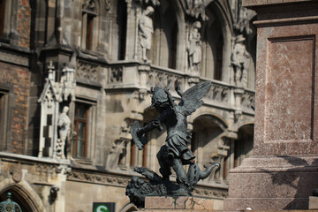 Fototapeta premium Close-up ancient statue of Putto killing devil at the Marian column's pedestal Marienplatz, Munich, Germany, travel destination backgrounds