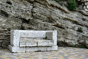 old stone bench against a background of travertine wall