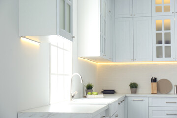Fototapeta na wymiar New ceramic sink and modern tap in stylish kitchen interior