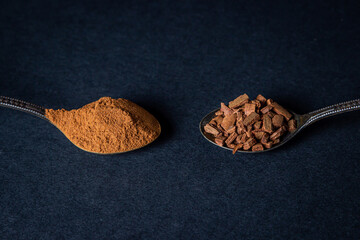 Cinnamon on a black background. A spoonful of young cinnamon lies next to a spoonful of crushed...