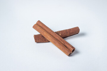 Cinnamon on a white background. Two cinnamon sticks, one on top of the other.