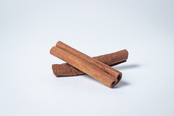 Cinnamon on a white background. Two cinnamon sticks, one on top of the other.