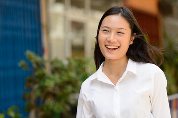Portrait of young beautiful Asian businesswoman outdoors