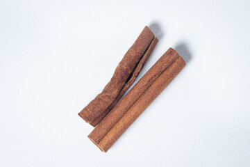 Cinnamon on a white background. Two cinnamon sticks, one next to the other. Photo from above