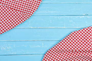 Tablecloth red and white checkerboard pattern on old blue wooden table with copy space.