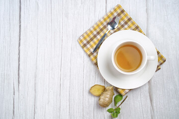 Top view of Cup of hot ginger tea with lemon and mint on wooden table. the concept of natural medicine.