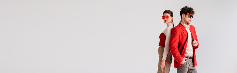 website header of young couple in fashionable autumn clothes posing isolated on grey
