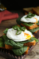 Delicious poached egg sandwiches served on wooden board