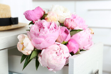 Bouquet of beautiful peonies in commode drawer indoors