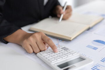 Asian woman is working on finances on her desk.