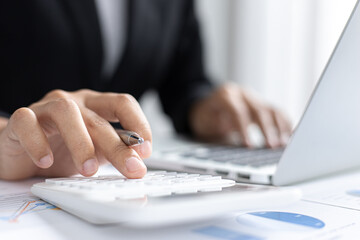 Asian woman is working on finances on her desk.