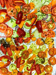 Before and after. Vegetables prepared for antipasto flavored with thyme, rosemary and olive oil at the top and Antipastos cooked in the oven at the bottom
