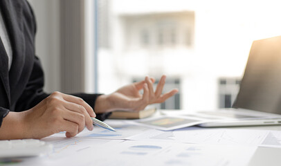 Asian woman is working on finances on her desk.