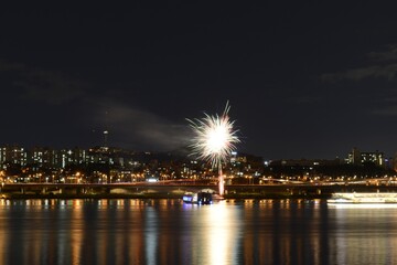 Fototapeta na wymiar Beautiful scenery of fireworks over an illuminated cityscape at Han-River in Seoul, South Korea