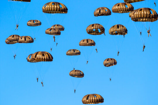 Group of military parachutist paratroopers in the sky during the Operation Market Garden memorial.