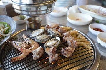 Closeup shot of oysters and shrimps on a grill at a Korean restaurant