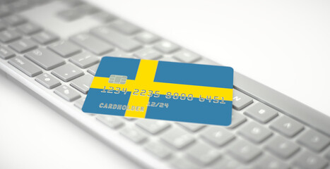 Credit card depicting flag of Sweden on computer keyboard. Fictional numbers