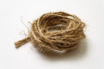 Jute twine isolated on white background. hank of twine close-up. jute rope for packing and decoration. skein of natural jute twine macroshot. Linen rough threads. raw material for industrial