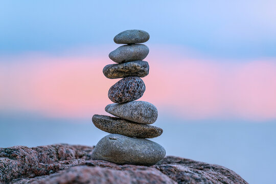 A small cairn placed on a rock at sunset