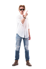 Confident successful young stylish man advertising and pointing finger upwards at side. Full body length isolated on white background. 