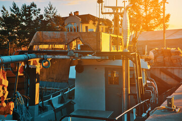 Boats in the port against the setting sun. Moored boats by the sea, sunset. The concept of sailing, spending time on a boat, sailboat.