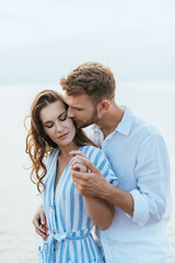 Obraz premium bearded man kissing and holding hands with attractive girl