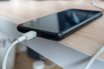 charging smart phone on a desk.