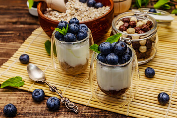 Healthy and useful breakfast concept. Yogurt with blueberries, oat-flakes and chia seeds