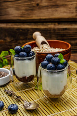 Healthy and useful breakfast concept. Yogurt with blueberries, oat-flakes and chia seeds