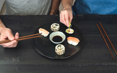 Two people eating sushi. Copy space. Food concept.