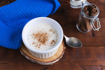 Creamy rice pudding and cinnamon on a wooden base. Pastry concept.