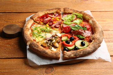 Slices of different delicious pizzas on wooden table