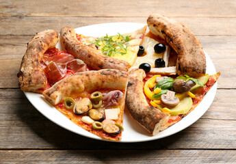 Slices of different pizzas on wooden table