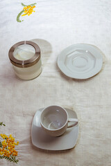 still life con taza de cafe con cuchara sobre mantel blanco decorado con bordado a mano
