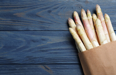 Fresh white asparagus on blue wooden table, top view. Space for text