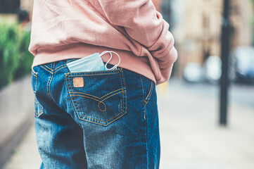 Face mask in pocket of jeans, stay safe and protect others concept, take your face covering with you