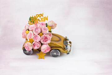 bouquet of pink roses in the car, stars and the inscription happy birthday