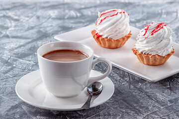 Freshly brewed aromatic coffee with cream and cake on gray background