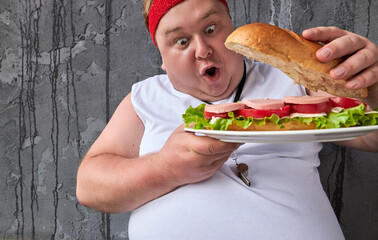 Wow fat man is surprised at a big sandwich, opens it and looks inside. handsome funny guy wants to eat after sport training