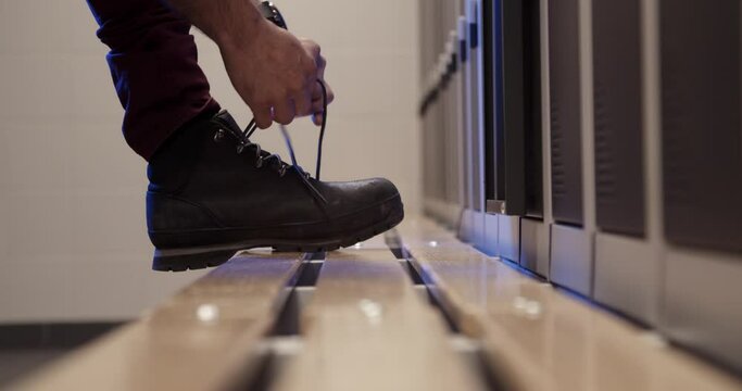 Man Tying The Laces On Leather Boot Over The Wooden Floor. Hands Of Man Tying Shoelaces. -  medium shot