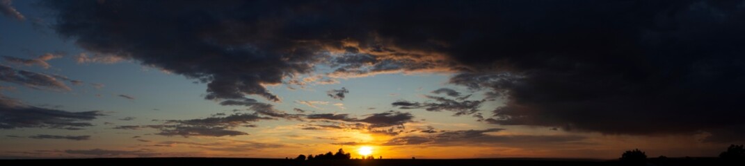 Panorama. Landscape with bloody sunset. Fantastic skies on the planet earth. Purple clouds. Tragic gloomy sky. Twilight.