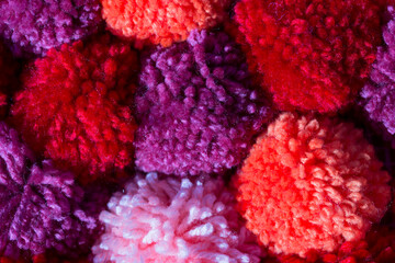 Background of red, pink and purple POM-poms.