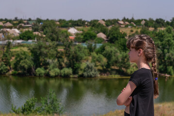 Fototapeta na wymiar The girl admires the beautiful view of the banks of the Dnieper. Travel healthy lifestyle